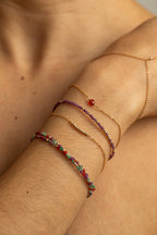 Bracelet Queen rubis porté avec d'autres bracelets dorés