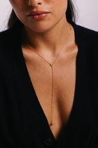 Collier Vice versa Stella or porté sur un blazer noir, pendant en forme de Y