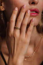 Maxi bague Héra portée à l'annulaire, main devant le visage, or 18 carats et diamants