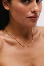 Collier Queen 40 cm or porté de profil, enfilage de perles dorées