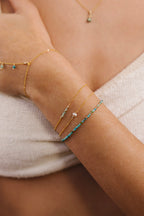 Bracelet Théa émeraude porté au poignet, or laminé 585/1000