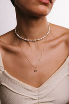 Petit pendentif Rosa porté en superposition de chaînes dorées