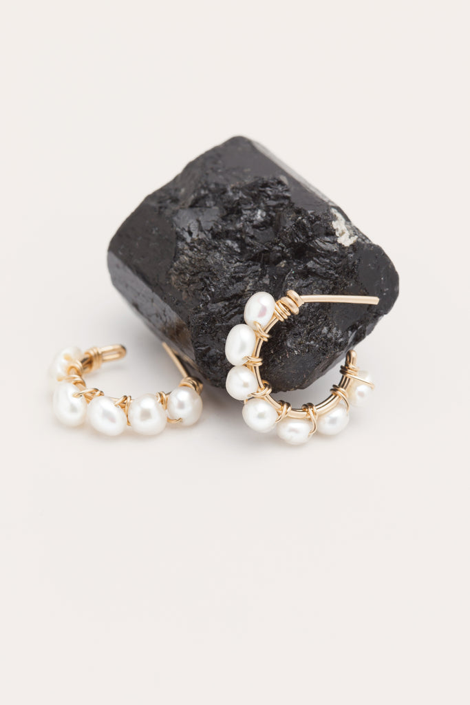 Focus créoles en perles de culture sur une pierre noir 