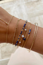 Bracelet Stella saphir porté avec plusieurs bracelets de pierres bleues